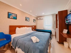 a hotel room with a bed with two slippers on it at Ponta Negra Beach Praiano Flat in Natal +41 photos
