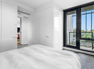 テンターフィールドにあるCharming 1-Bed Farm Cabin with Wood Fireの白いベッドと大きな窓のある寝室