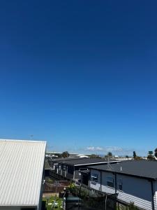 a view of houses and the ocean in the distance at Mount Breeze in Mount Maunganui +10 photos