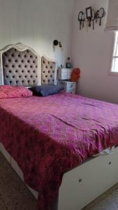 a bedroom with a large bed with a purple comforter at Encantador estudio en Chacaito- Excelente ubicación in Caracas