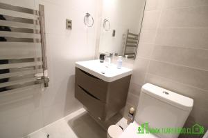 a white bathroom with a sink and a toilet at MPH 204 Departamento en Puerto Varas a pasos del Lago, para 6 personas in Puerto Varas +21 photos