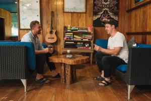 two men sitting in a room with a guitar at Amazon Muyuna Lodge - All Inclusive in Paraíso