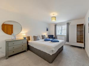 a bedroom with a bed with a dresser and a mirror at 4 Bed in Llandudno 89703 in Deganwy
