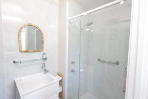 ein weißes Badezimmer mit Dusche und Waschbecken in der Unterkunft Heritage Home with BBQ & Outdoor Fire Pit in Tenterfield + 26 Fotos