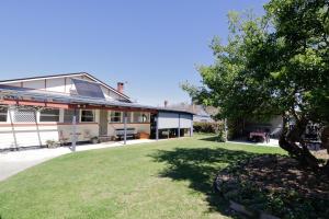 ein Haus mit einem Rasen davor in der Unterkunft Heritage Home with BBQ & Outdoor Fire Pit in Tenterfield