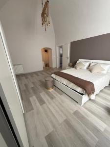 a white bedroom with a large bed and wood floors at Ad un Passo dal Duomo in Bovino