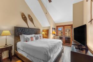 ein Schlafzimmer mit Bett und Flachbildfernseher in der Unterkunft Arapahoe Lodge 8137 in Snake River Health Services Incorporated Heliport