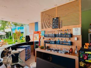 a bar in a restaurant with a counter with drinks at Ponta Negra Beach Praiano Flat in Natal