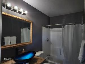 a bathroom with a large mirror and a blue bowl at Sunrise Springs in Pahrump +31 photos