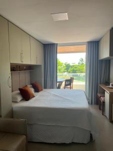 a bedroom with a large bed and a large window at Flat in Tamandaré