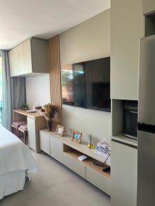 a room with a bed and a kitchen with at Flat in Tamandaré