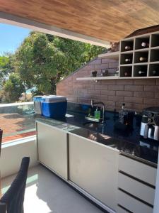 a kitchen with a sink and a large window at Flat in Tamandaré