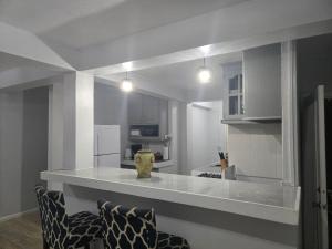 a kitchen with a white counter top with two chairs at Jean Olive in Castries +23 photos