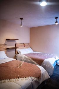 two beds in a room with lights on the wall at Cielito Lindo Hotel Boutique 