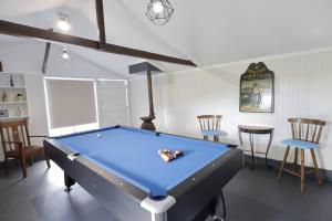a pool table in a living room with at Homely 2-Bed Cottage Near Tenterfield Centre in Tenterfield