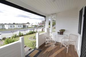 eine Veranda mit zwei Stühlen und einem Tisch darauf in der Unterkunft Homely 2-Bed Cottage Near Tenterfield Centre in Tenterfield