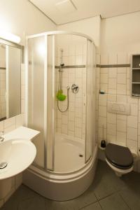 ein Bad mit einer Dusche, einem WC und einem Waschbecken in der Unterkunft Seminarhaus in der Akademie in Waren (Müritz)