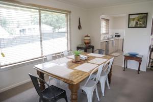 テンターフィールドにあるFamily Retreat in Central Tenterfieldの木製のテーブルと白い椅子のあるダイニングルーム