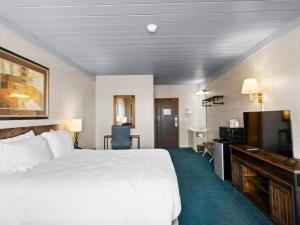 a hotel room with a bed and a flat screen tv at 1st Choice Inn of Rawlins in Rawlins
