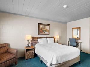 a bedroom with a bed and a couch and a chair at 1st Choice Inn of Rawlins in Rawlins