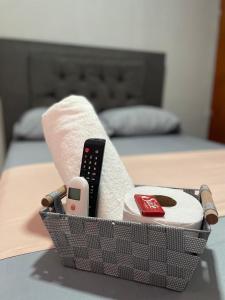een mand op een bed met een afstandsbediening bij hotel Siboney - Centro in Estación El Salto