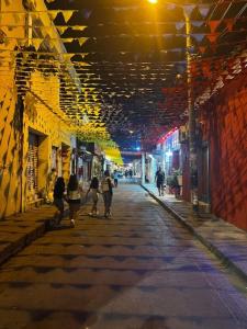 een stadsstraat met mensen die 's nachts over straat lopen bij hotel Siboney - Centro in Estación El Salto