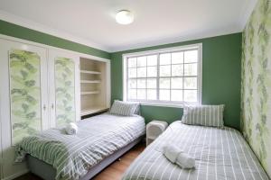 Dos camas en una habitación con paredes verdes. en Country 4-Bed Homestead with Games Room & Views, en Tenterfield