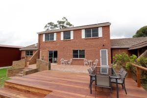 patio trasero con terraza de madera con mesa y sillas en Country 4-Bed Homestead with Games Room & Views, en Tenterfield