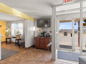 a living room with a sliding glass door with a view of a room at 1st Choice Inn Rawlins in Rawlins