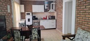 eine Küche mit einem Tisch und einer Ziegelwand in der Unterkunft Nuevo Complejo Milena in San Juan