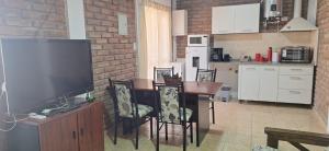 a kitchen with a table with chairs and a television at Milena 1, parking amplio y WiFi Starlink in San Juan