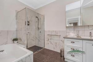 Un baño blanco con ducha y lavabo. en Campaspe Central - Your Central Echuca Escape!, en Echuca 13 fotos más