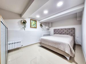 um quarto com uma cama em um quarto branco em BunApart Ciorescu Cristal em Ciorescu mais 35 fotografias