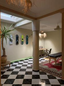 una habitación con suelo ajedrezado, una columna y una mesa en The FlowHost, en Tamraght Ouzdar