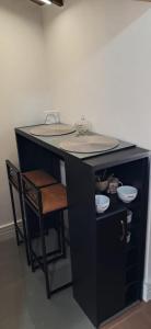 einen schwarzen Schreibtisch mit einem Tisch und einem Stuhl in der Unterkunft Le Flat Petrópolis in Petrópolis