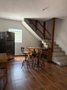 a kitchen with a table and a refrigerator and a staircase at Chale com Hidromassagem na Serra do Cipó in Santana do Riacho