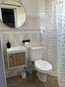 a bathroom with a toilet and a sink and a mirror at Chale com Hidromassagem na Serra do Cipó in Santana do Riacho
