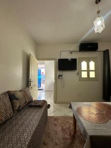 Una sala de estar con un sofá y una ventana. en A unique and cute apartment in a prime location, en Er Rachidia