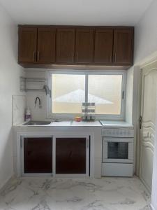 una cocina con fregadero y ventana en A unique and cute apartment in a prime location, en Er Rachidia