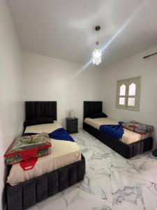 2 camas en una habitación con suelo de mármol en A unique and cute apartment in a prime location, en Er Rachidia