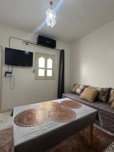 una sala de estar con una mesa y un sofá en A unique and cute apartment in a prime location, en Er Rachidia 8 fotos más