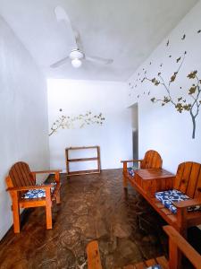 una habitación con 2 sillas y una mesa con pájaros en la pared en Casa Jedidian, en El Cuyo