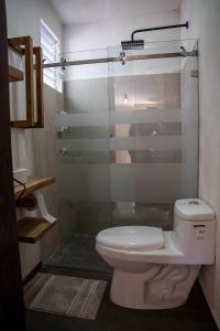 a bathroom with a toilet and a glass shower at Cielito Lindo Hotel Boutique 