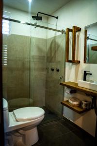 a bathroom with a shower and a toilet and a sink at Cielito Lindo Hotel Boutique 