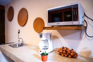 a kitchen counter with a coffee maker and a microwave at Cielito Lindo Hotel Boutique  +10 photos