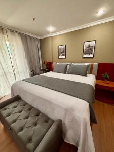 a large bedroom with a large bed with a couch at Flat Barra Residence-3 pessoas-Fa1204-4 in Rio de Janeiro +50 photos