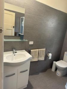 a bathroom with a sink and a toilet at The Cottage at Raheen in Mallacoota +6 photos
