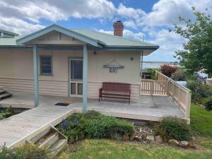 a house with a bench on a porch at The Cottage at Raheen in Mallacoota