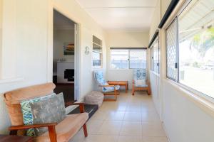 ein Wohnzimmer mit zwei Stühlen und einem Tisch in der Unterkunft Cypress Cottage 26 Cypress Street Evans Head in Evans Head