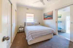 ein Schlafzimmer mit einem Bett und einem Fenster in der Unterkunft Cypress Cottage 26 Cypress Street Evans Head in Evans Head